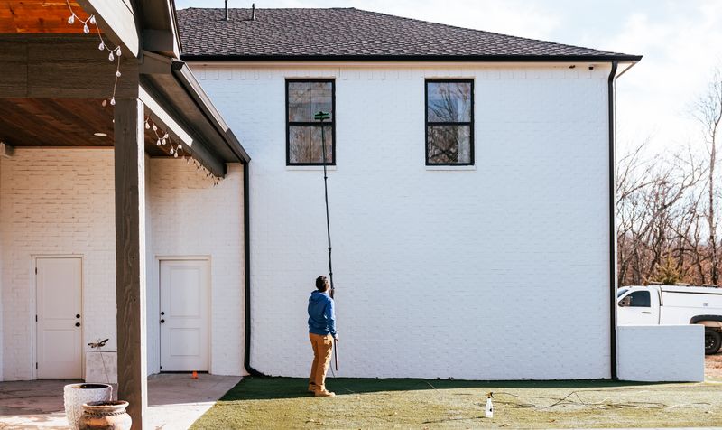 Better View team member cleaning exterior second-story windows with a pole